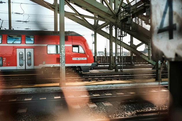 Ein rot-weißer Zug auf einer Brücke.